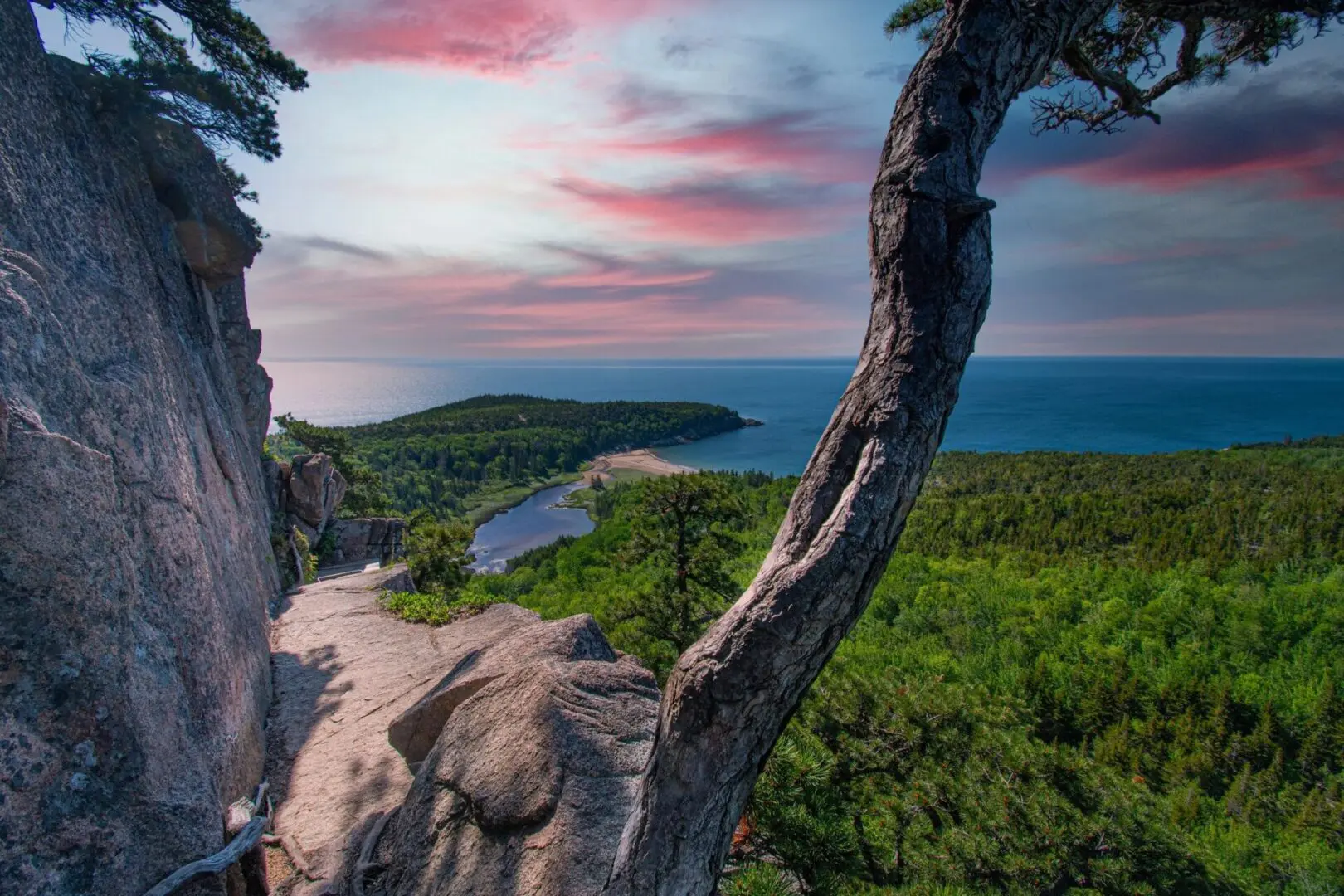 Coastal cliffside path with sunset sky.